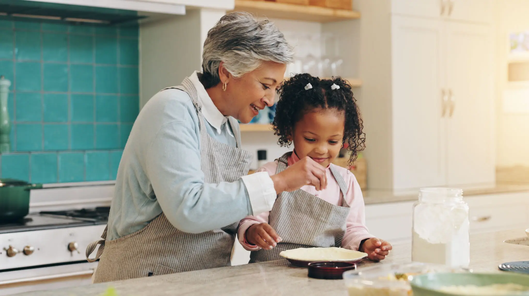 Grandmother and child baking in kitchen together.