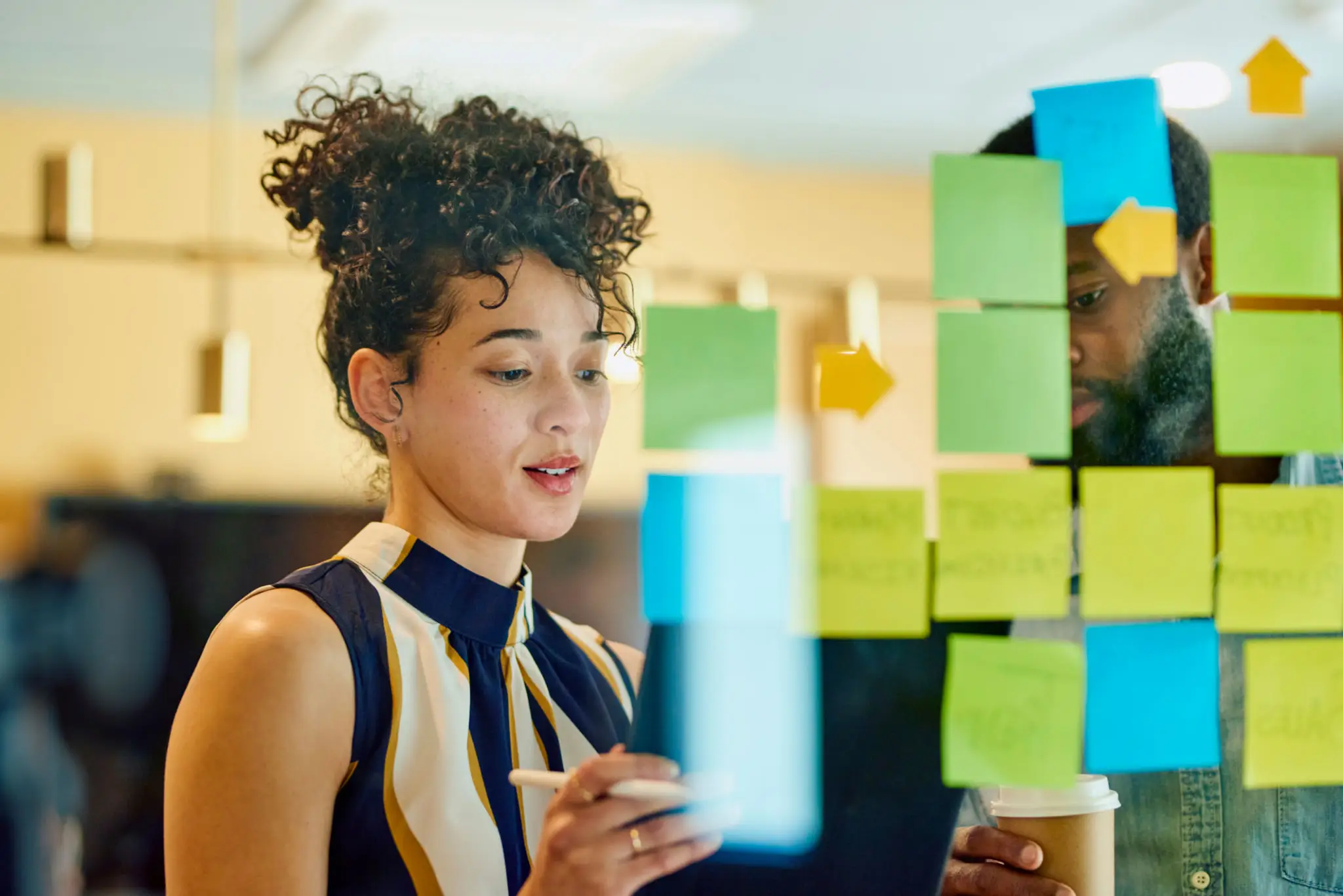 Two people collaborating with sticky notes.