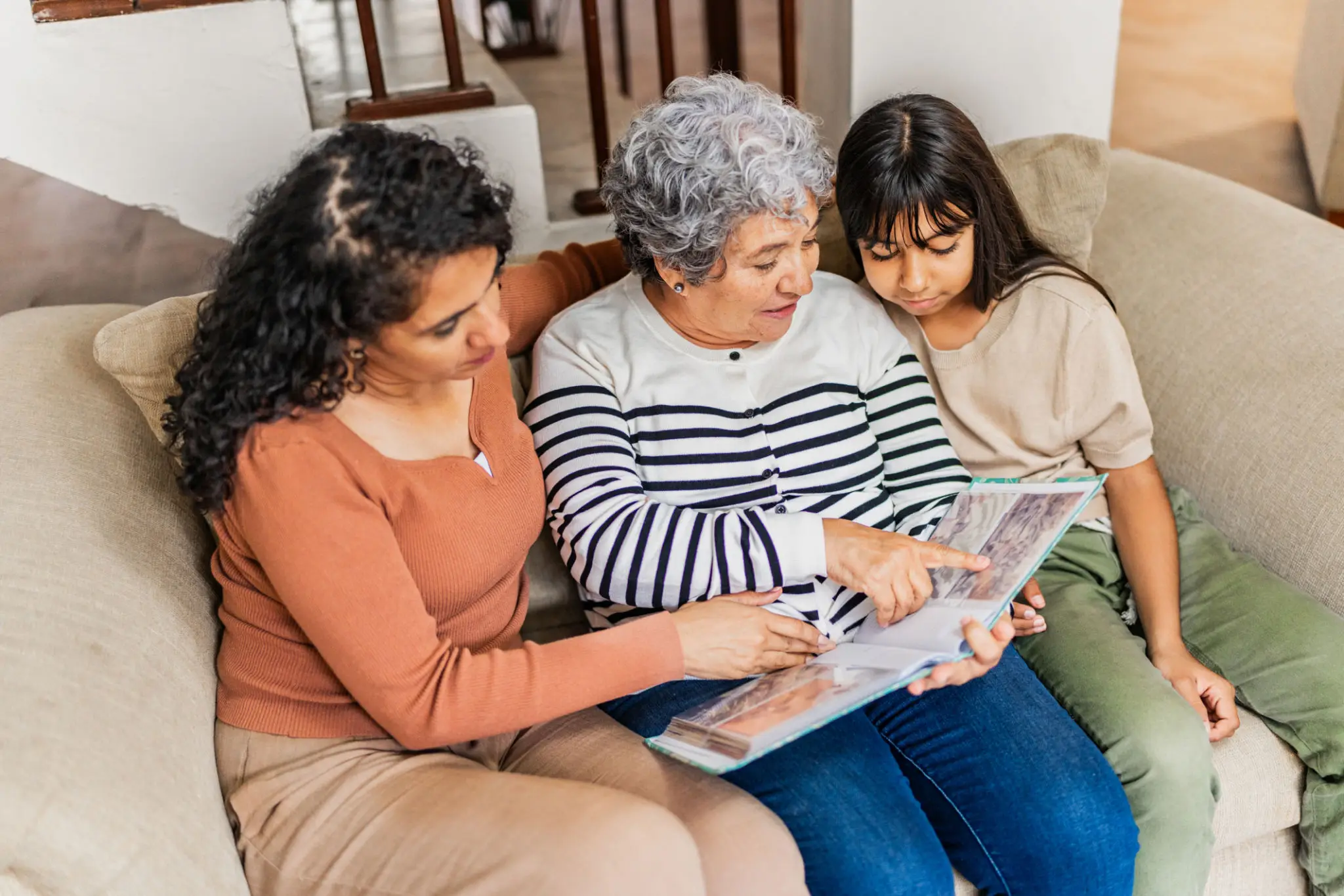 Three people looking at a photo album.